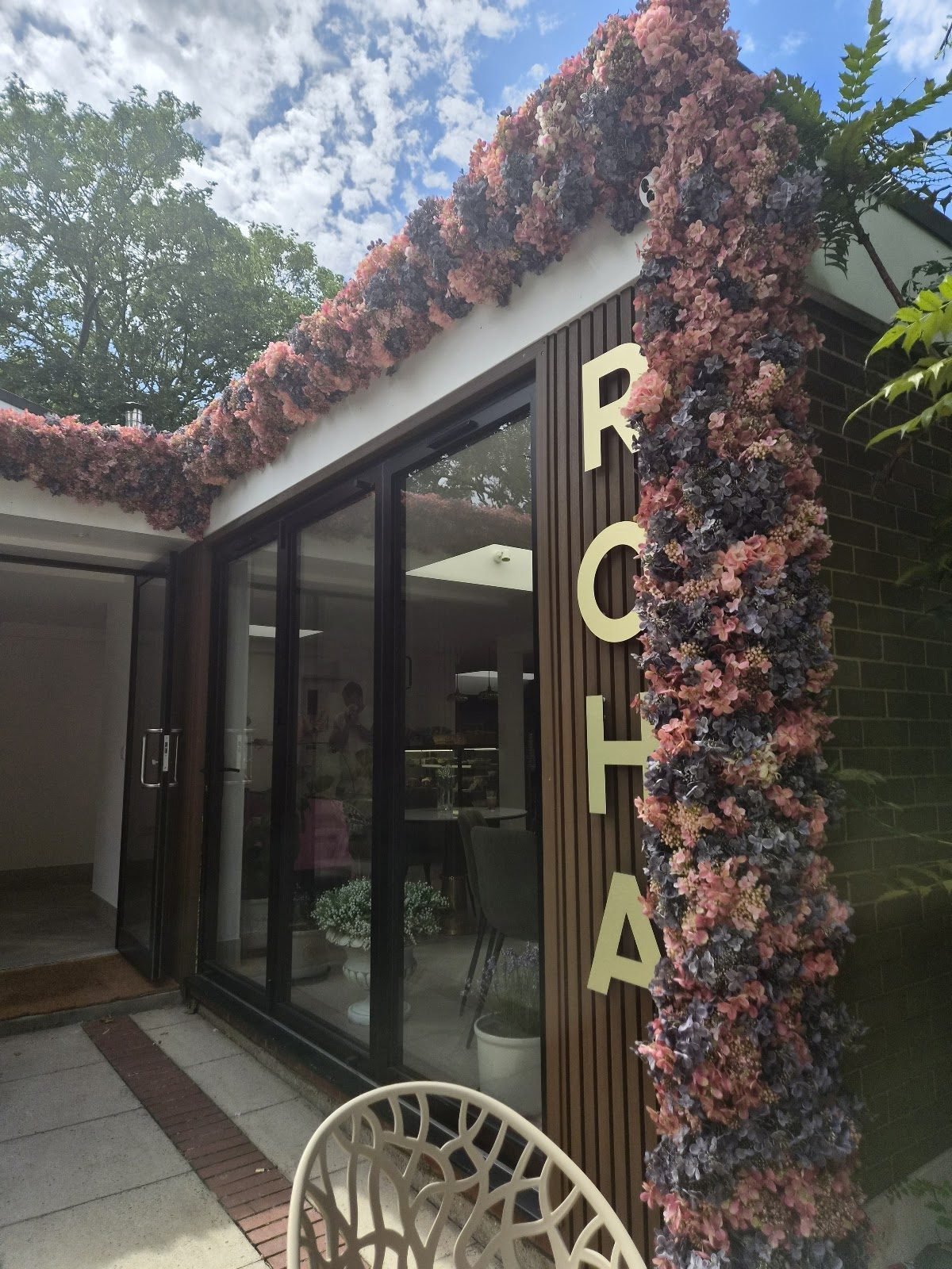 ROHA Cafe's entrance framed by pink and blue dried-flower garlands